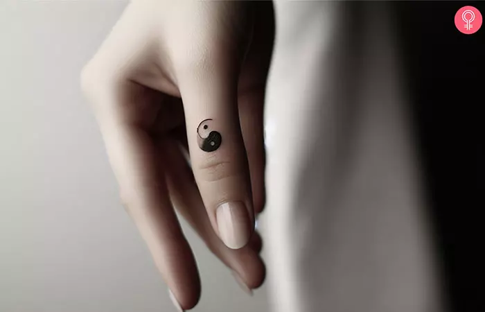 A yin yang tattoo on the thumb