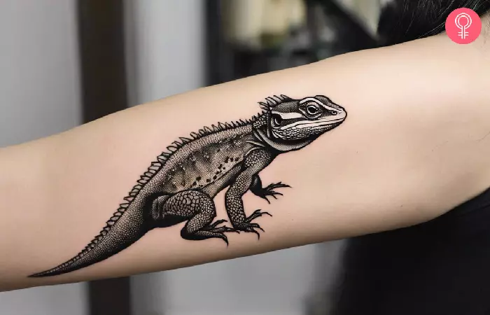 woman with a simple bearded dragon tattoo on her arm