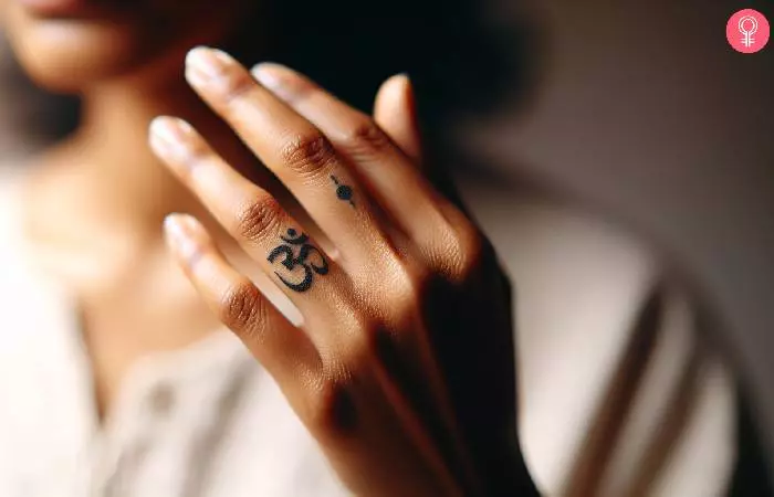woman with a small Hindu tattoo on her fingers