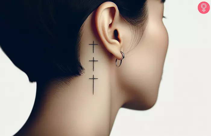 3 small crosses tattoo behind the ear