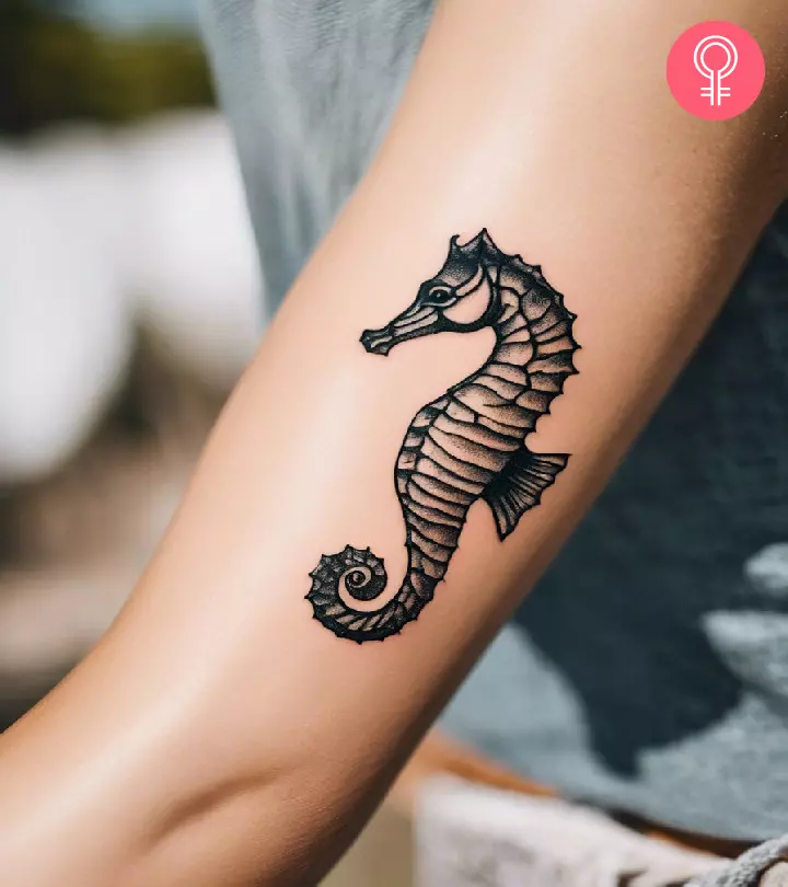 Woman with a seahorse tattoo on her arm.