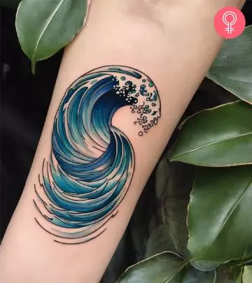 A woman with a wave tattoo on her upper arm