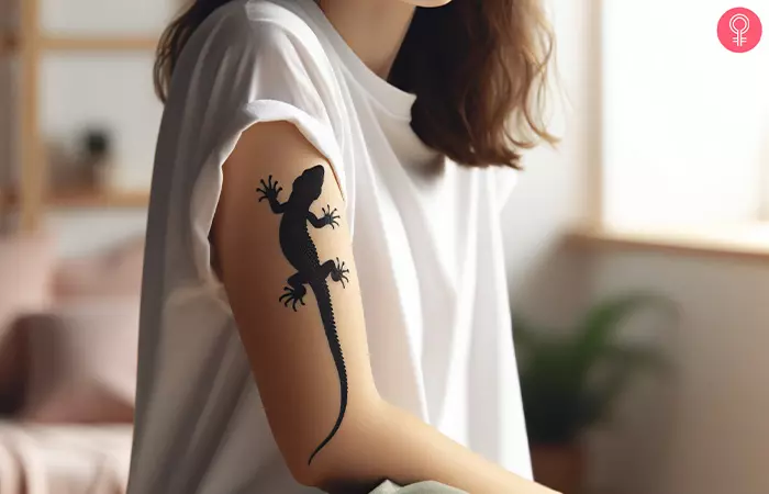 A 3D lizard tattoo on the arm of a woman