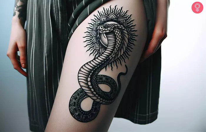 A black cobra tattoo on the thigh