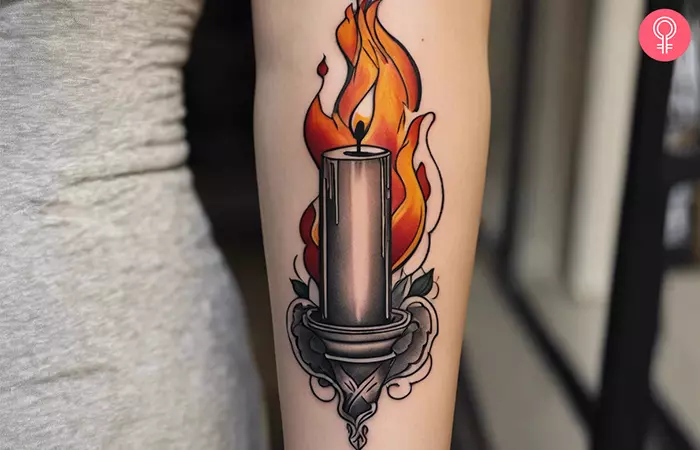 A burning candle tattoo on the arm