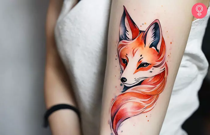A feminine kitsune tattoo on a woman’s upper arm