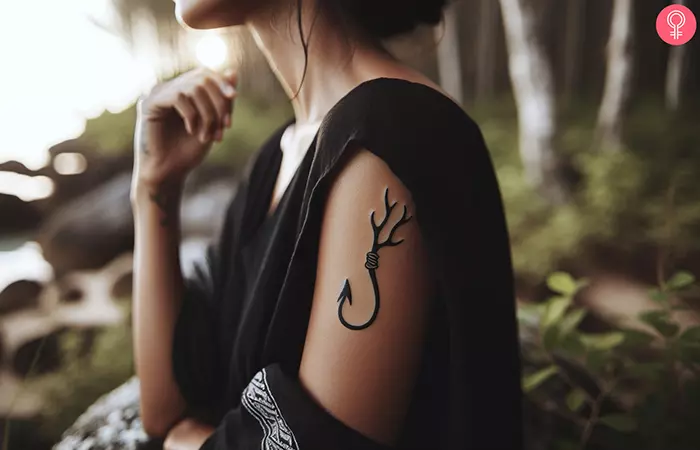 A fish hook with antlers tattooed on the arm