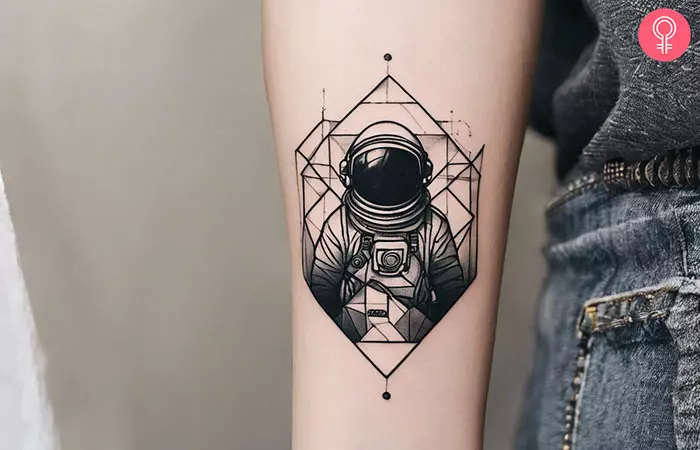 A geometric astronaut tattoo on a woman’s forearm