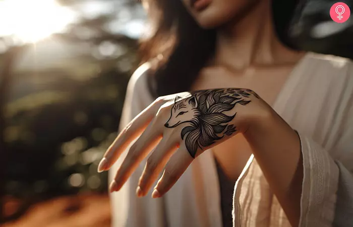 A kitsune tattoo on the hand of a woman