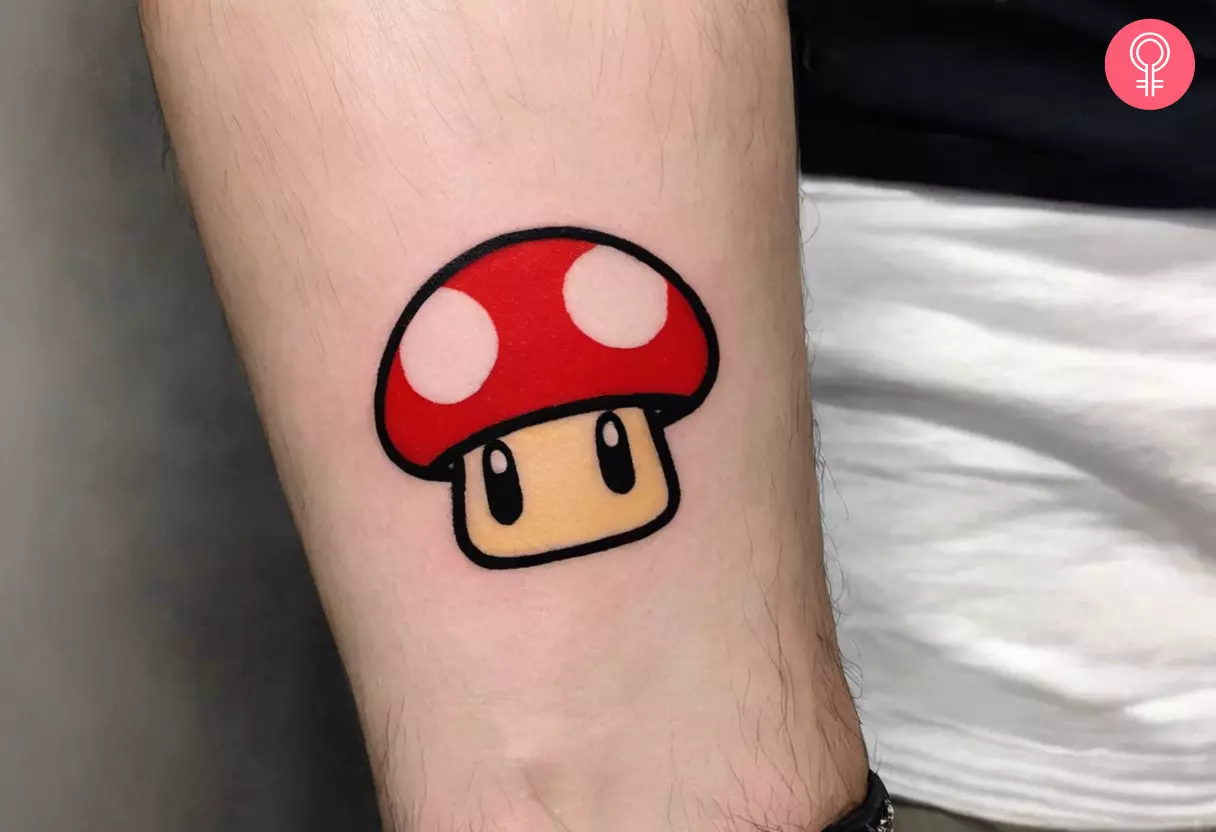 A man with a Mario mushroom tattoo on his forearm