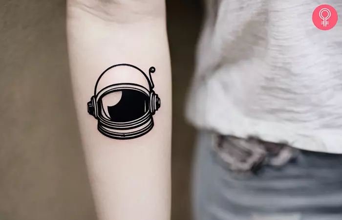 A minimalist astronaut tattoo on a woman’s forearm