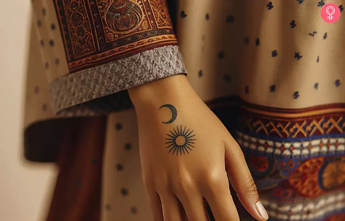A minimalist sun and moon hand tattoo