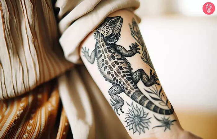 A realistic lizard tattoo on the arm of a woman
