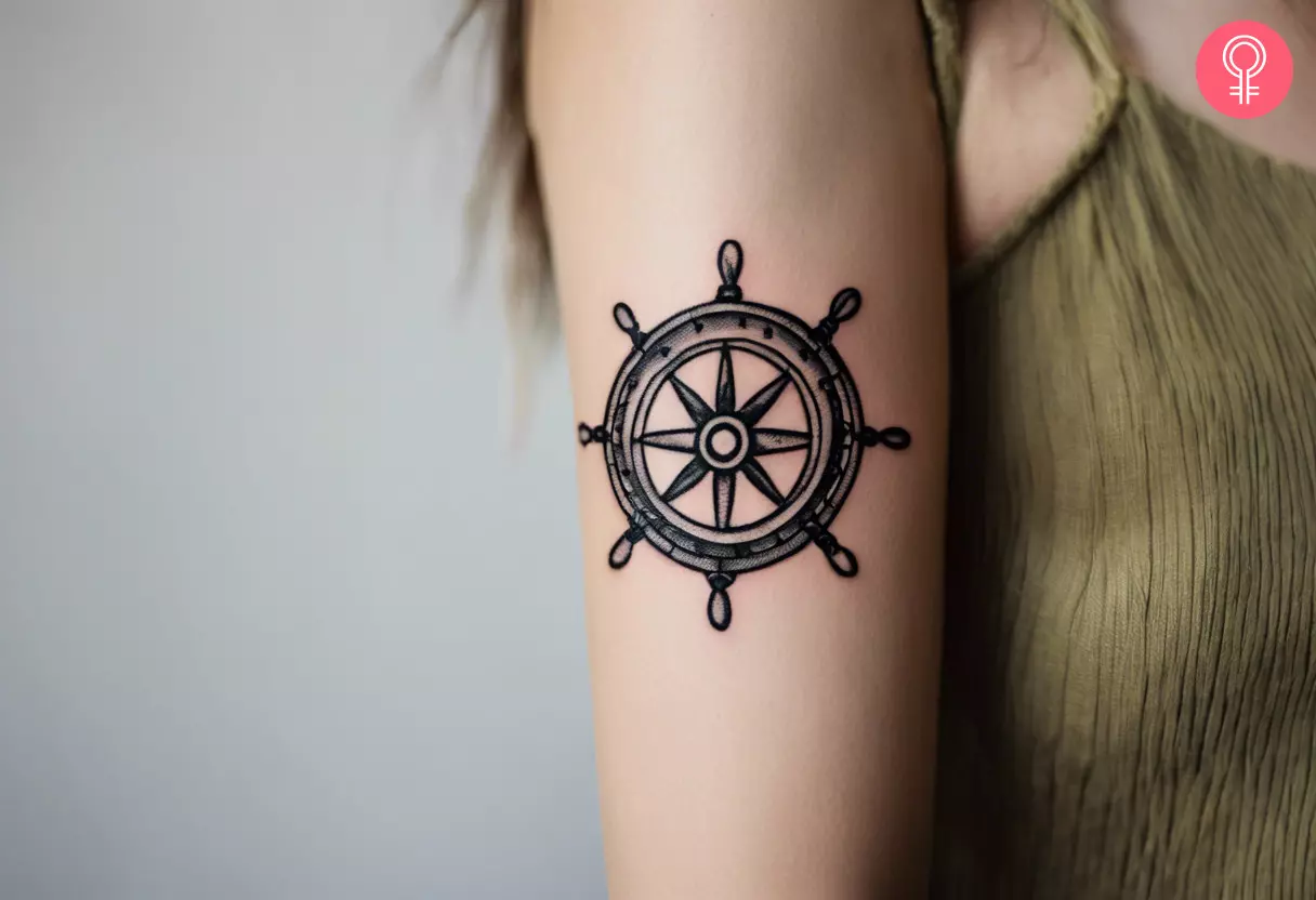 A ship wheel tattoo on the upper arm