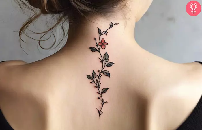 A small and delicate flower vine tattoo on the back of the neck