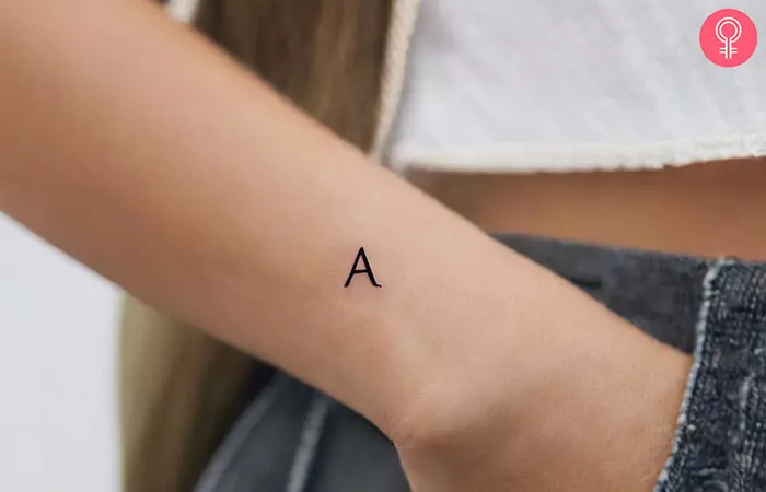 A small letter A tattoo on a woman’s forearm