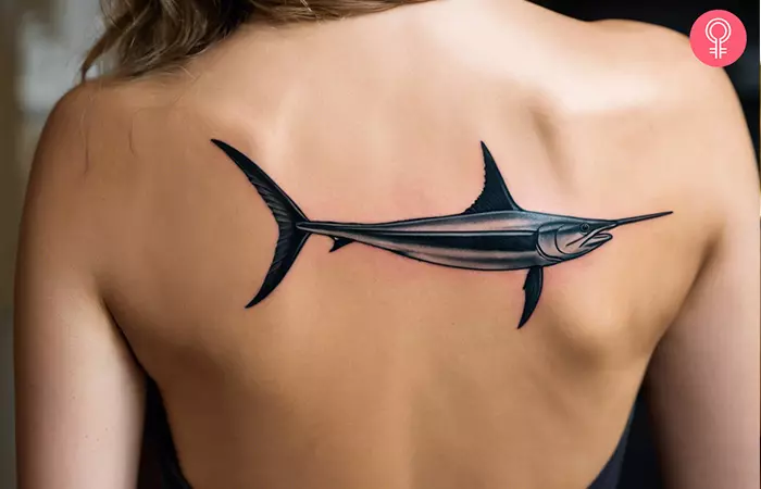 A swordfish tattoo on the back of a woman