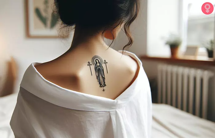 A tattoo of Jesus with 3 crosses on a woman’s back