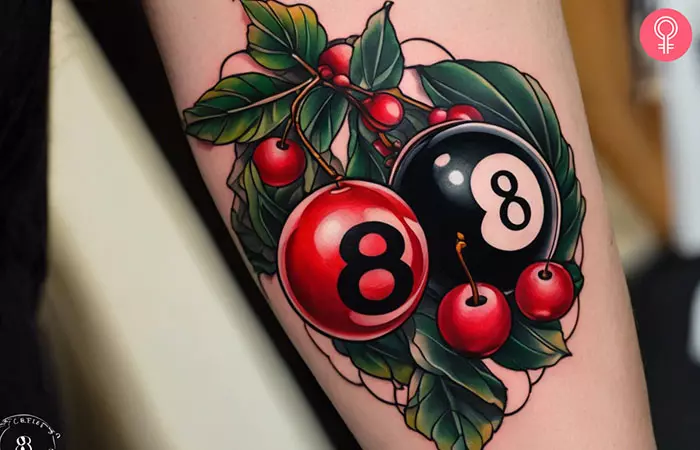 A tattoo of an 8 ball and cherries on the arm