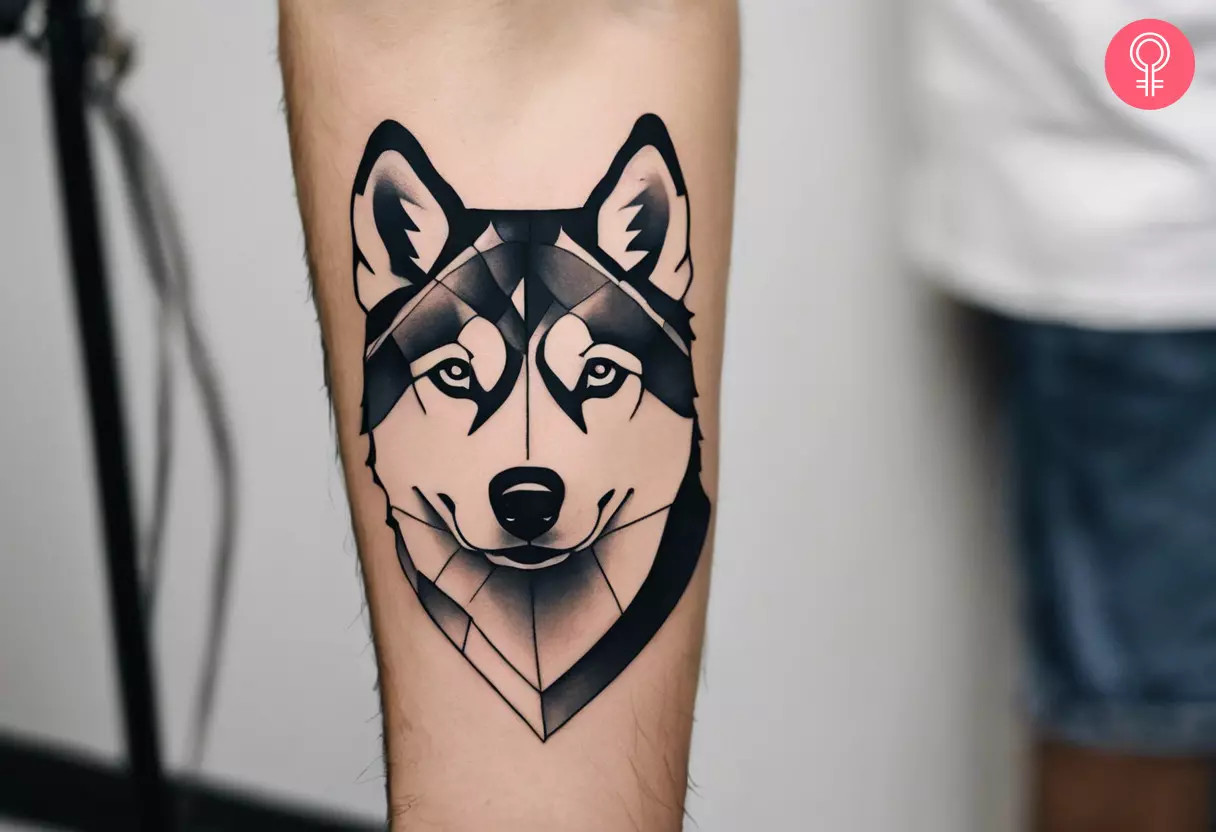 A tattoo on the arm of a man showing the outline of a husky