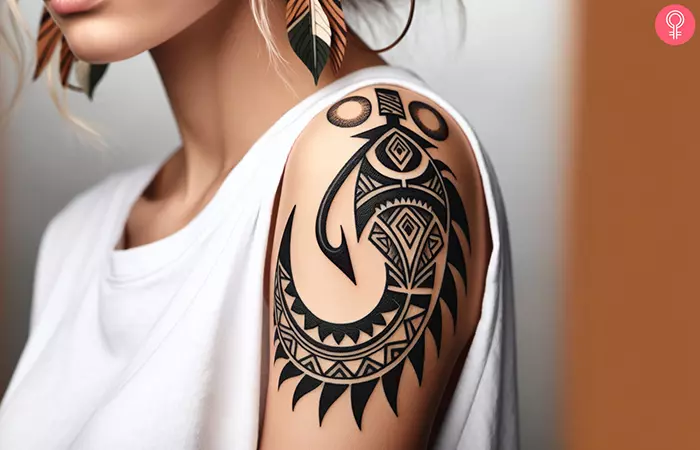 A tribal fish hook tattoo on the shoulder
