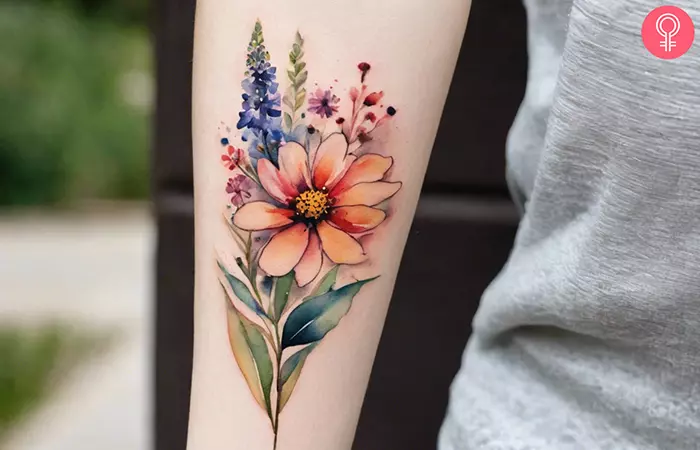 A watercolor wildflower tattoo on the forearm