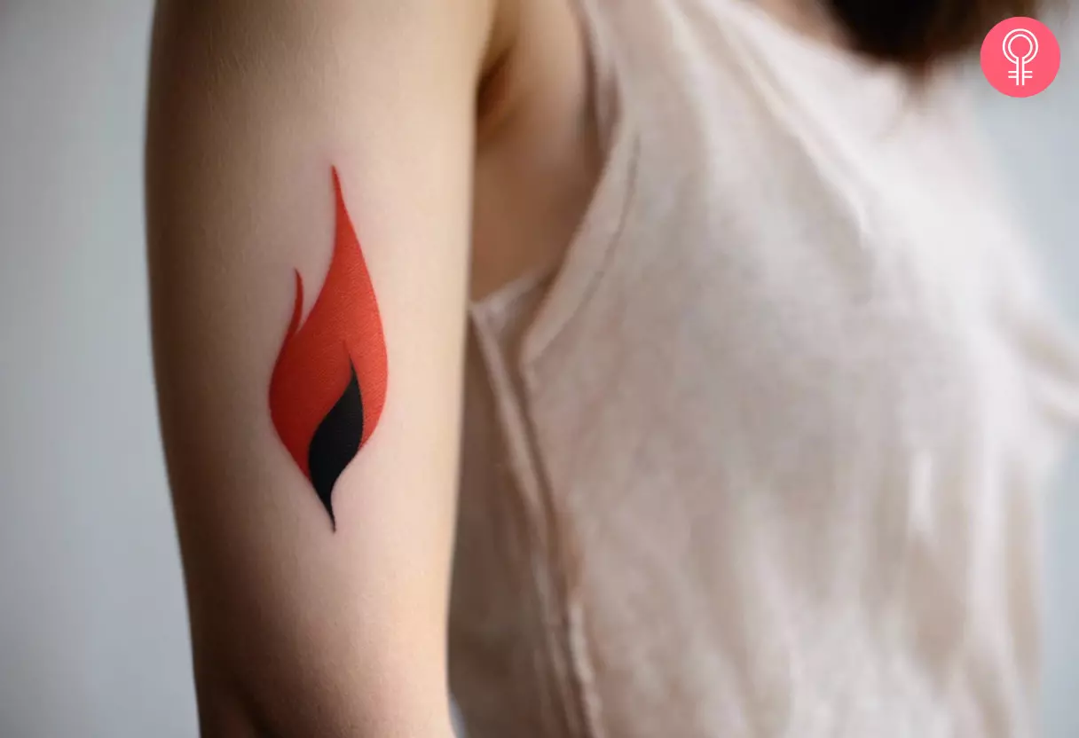 A woman flaunting a cute red flame tattoo on the upper arm