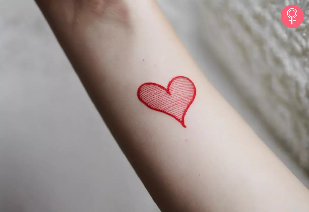 A woman flaunting a minimalist red ink tattoo on her inner arm