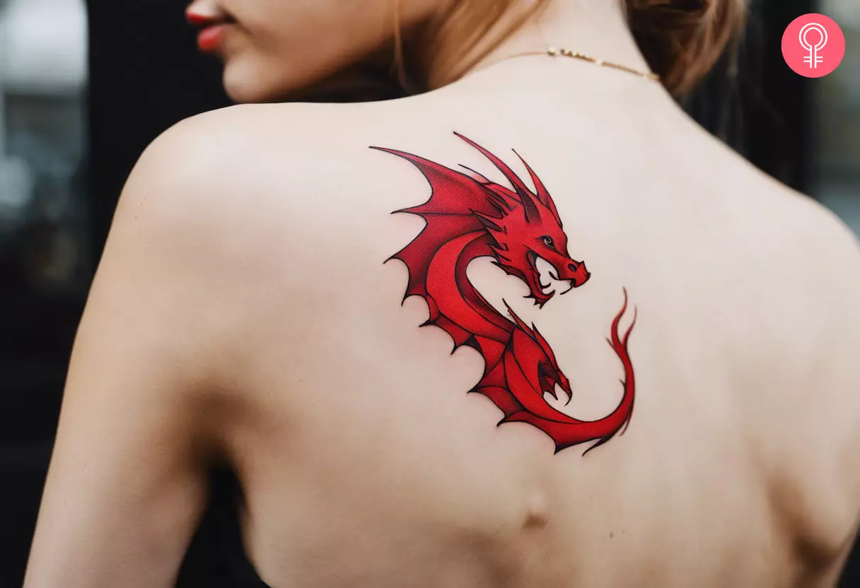 A woman flaunting a red dragon tattoo on the back