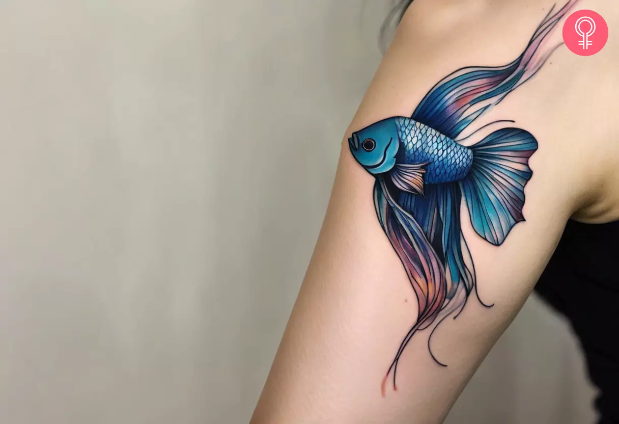 A woman sporting a betta fish tattoo on her upper arm