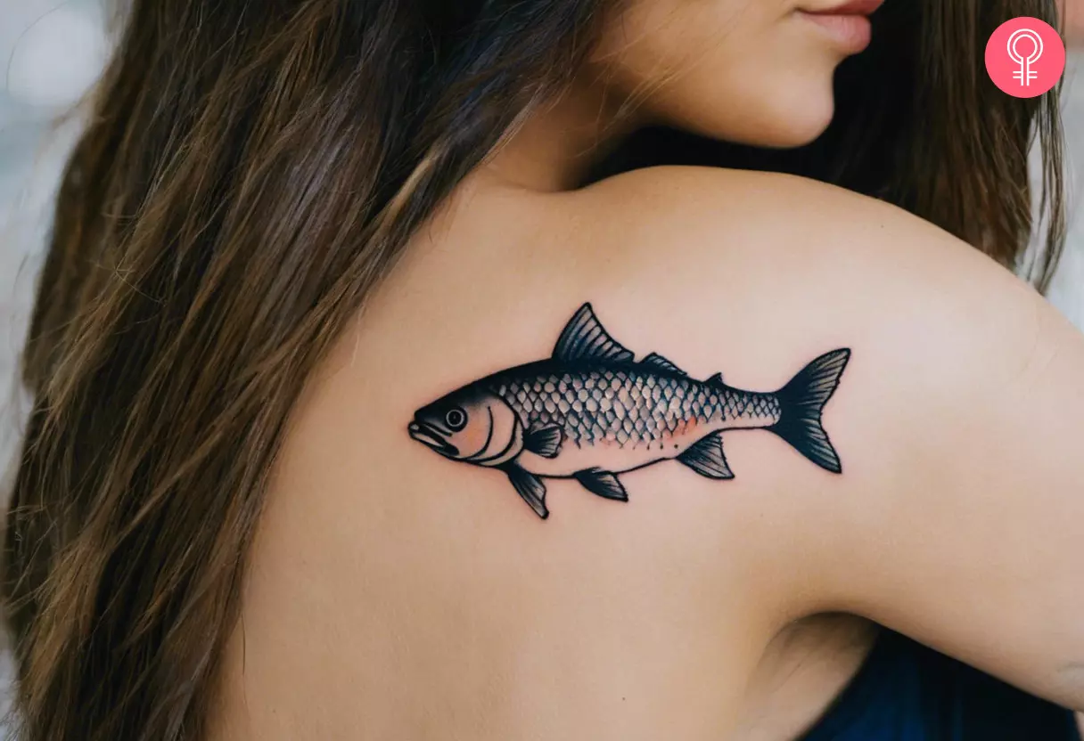 A woman sporting a traditional fish tattoo on her shoulder blade