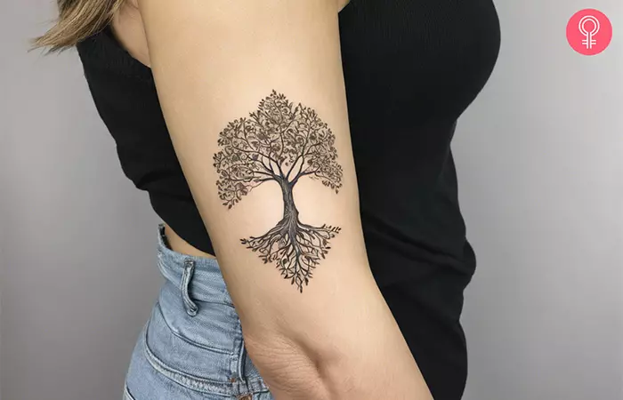 A woman with a classical Yggdrasil tree tattoo on her arm