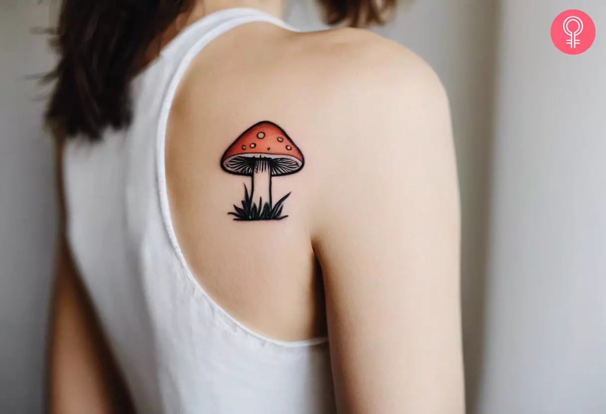 A woman with a small mushroom tattoo on the back of her shoulder