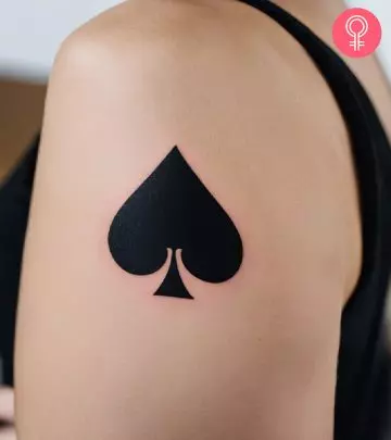 A woman with an ace of spades tattoo on her upper arm