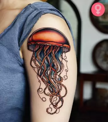 A rainbow-colored heart tattoo on the inner upper arm of a woman