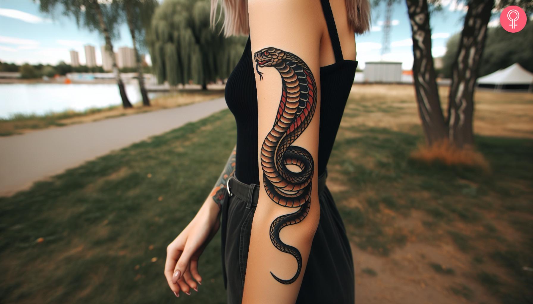 A cobra tattoo inked on the side of a woman’s arm