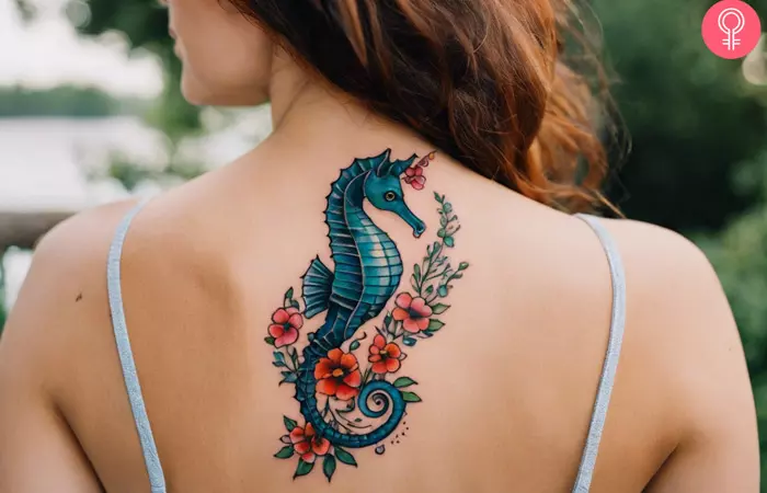 A woman with an American-style traditional seahorse tattoo on her upper back