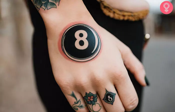 An 8 ball tattoo on the hand