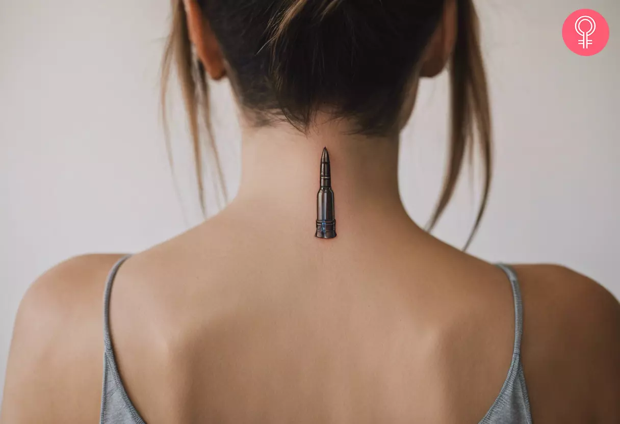 An AK-47 bullet tattoo on the back of a woman’s neck