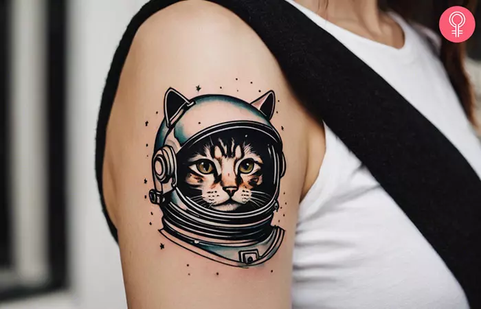 An astronaut cat tattoo on a woman’s upper arm