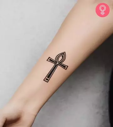 A cross tattoo behind ear