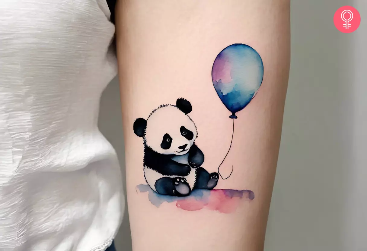 A woman with a baby panda tattoo on the forearm