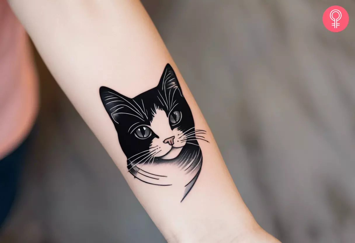 Black and white cat tattoo on a woman’s arm