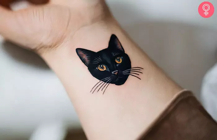 A black cat tattoo on the upper arm