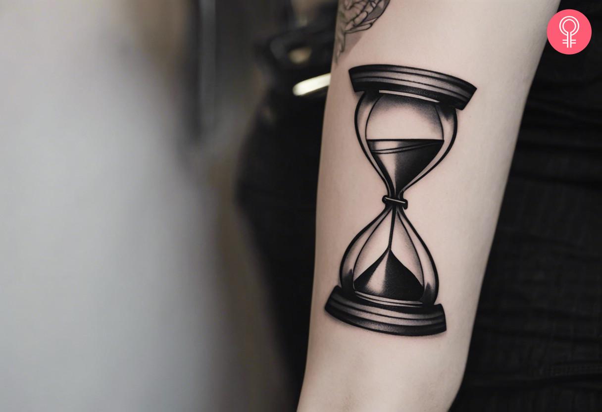 Black and grey hourglass tattoo on the arm