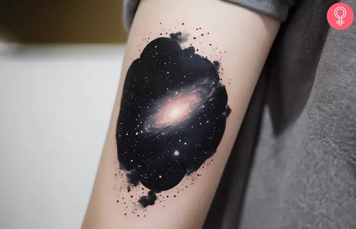 Black galaxy tattoo on the upper arm