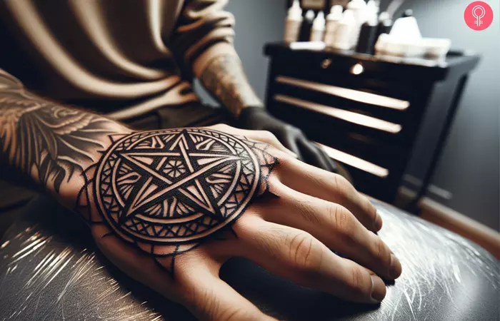 A blackwork pentagon tattoo on the hand