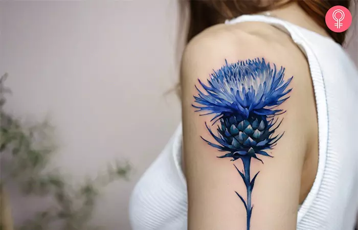 Blue thistle tattoo on the shoulder