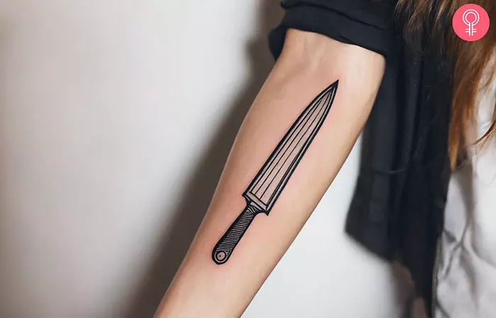 A chef knife tattoo on the forearm