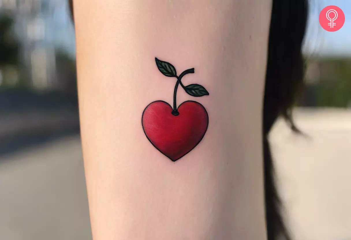 A heart cherry tattoo on the forearm